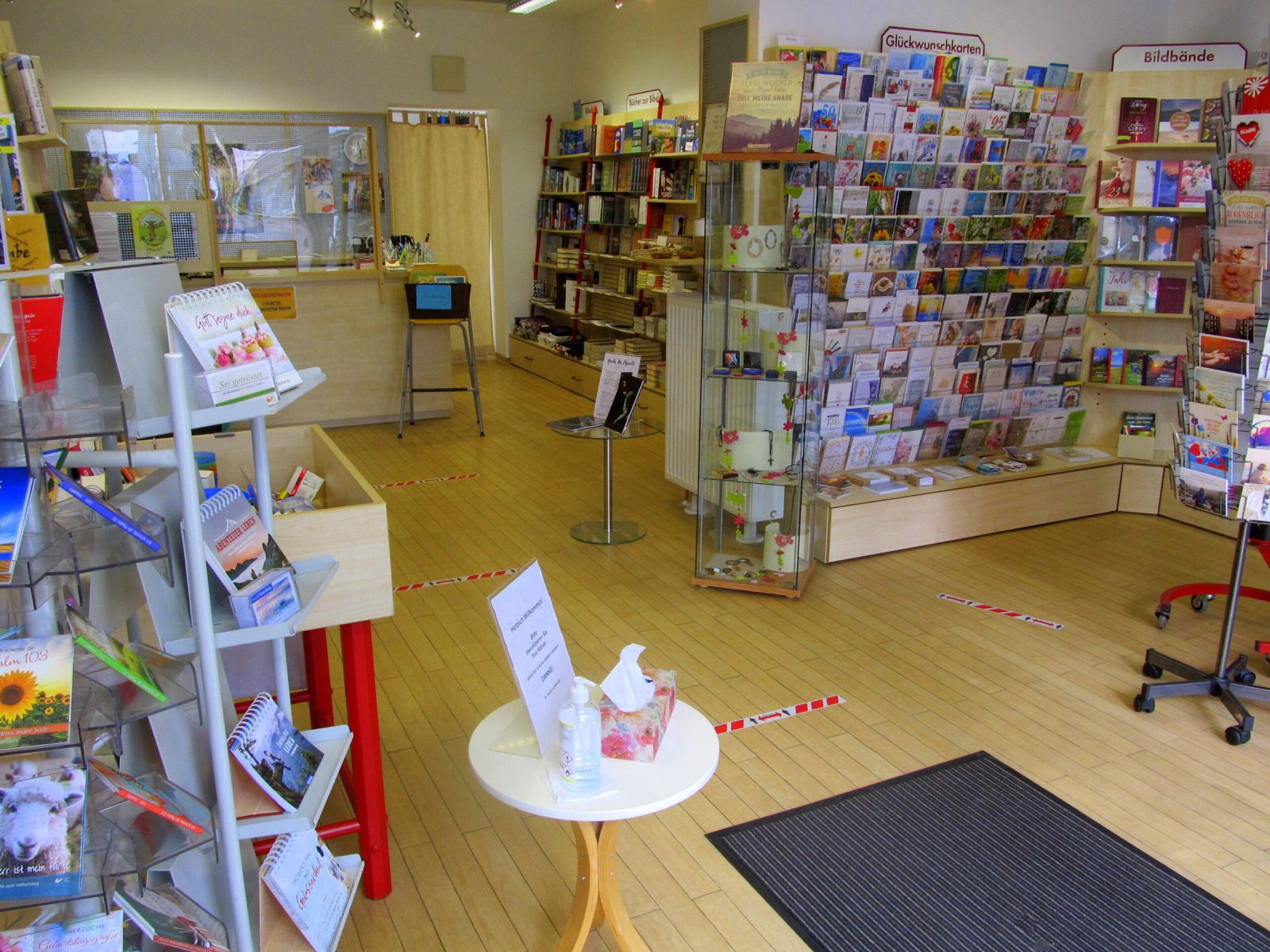 Verkaufsraum mit Kartenständern, Bücherregalen und Theke