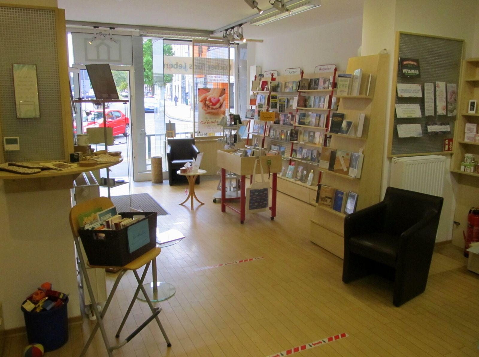 Blick durch die Bücherstube zum Eingang mit Sessel und Regalen